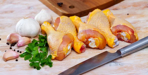 stock image Raw poultry, fresh chicken legs with condiments on wooden table