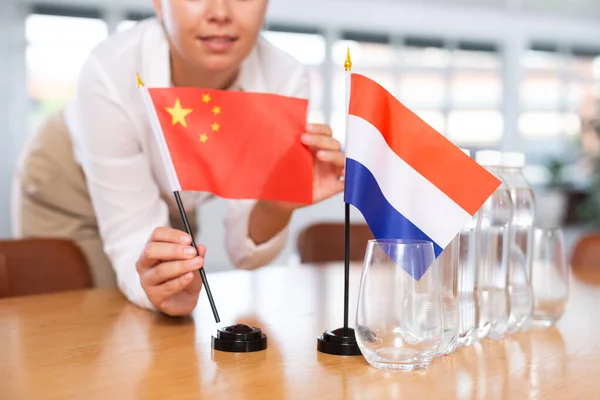Young Woman Business Clothes Puts Flags China Netherlands Negotiating Table — Stock Photo, Image