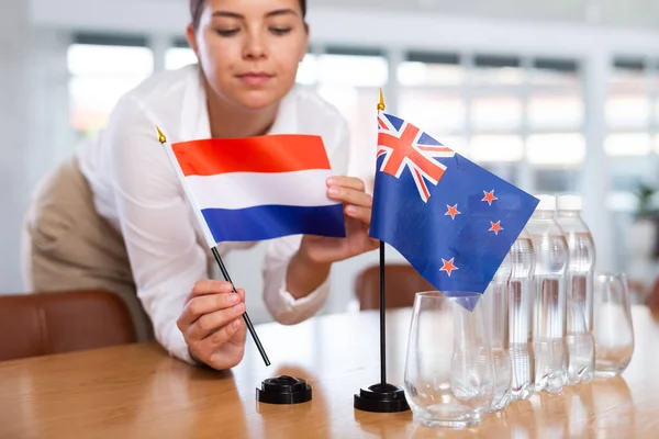 Kadın Sekreter Görüşmeler Için Bir Ofis Hazırlıyor Hollanda Avustralya Bayraklarını — Stok fotoğraf