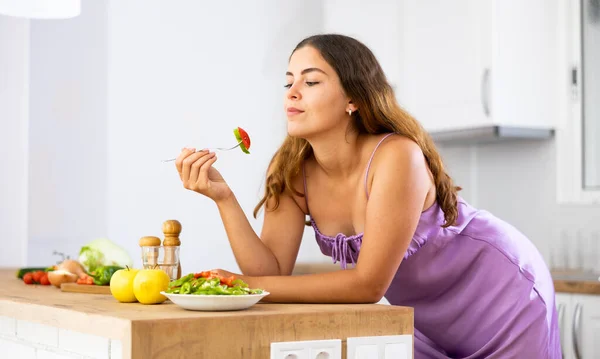 Retrato Menina Positiva Camisola Roxa Degustação Salada Legumes Cozinha — Fotografia de Stock