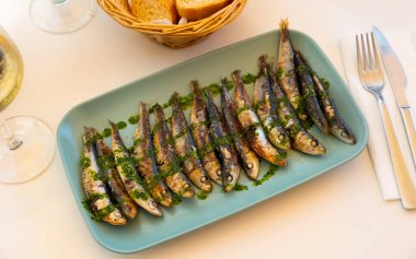 Dish with fried sardines, pilchards or anchovies in batter for a traditional Spanish meal clipart