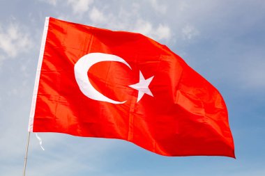 Turkish flag waving against the blue sky clipart