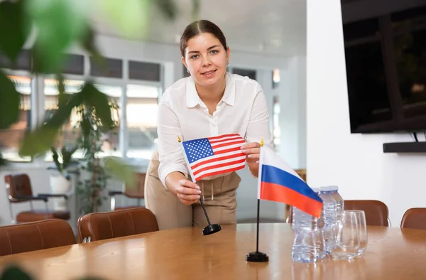 Young Woman Business Clothes Puts Flags Usa Russia Negotiating Table — Stock Photo, Image