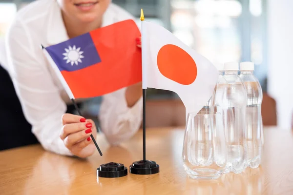 Manos Femeninas Colocando Banderas República China Taiwán Japón Sobre Mesa —  Fotos de Stock