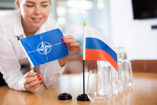 Jovem Roupas Negócios Coloca Bandeiras Otan Rússia Mesa Negociações Escritório — Fotografia de Stock