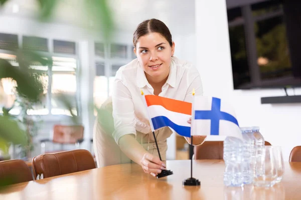 Young Female Assistant Setting Flags Finland Netherlands Table International Negotiations — Stock Photo, Image