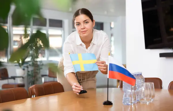Jovem Mulher Roupas Negócios Coloca Bandeiras Suécia Rússia Mesa Negociação — Fotografia de Stock