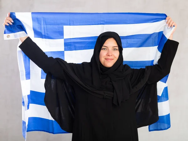 身穿黑色传统头巾 手持希腊国旗的快乐的年轻穆斯林妇女 — 图库照片