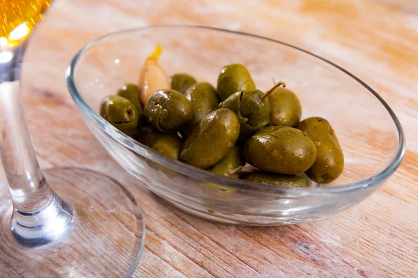 Light and nutritious snack awaits, consisting of handful of pickled green pitted olives and slice of wholesome bran bread.