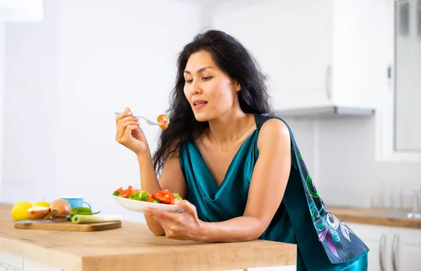 亚洲女人靠在厨房桌子上吃沙拉 女人早上吃蔬菜沙拉 吃健康早餐 — 图库照片