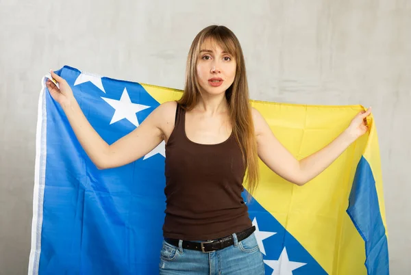 Zdenerwowana Młoda Kobieta Trzymająca Rękach Wielką Flagę Bośni Hercegowiny — Zdjęcie stockowe