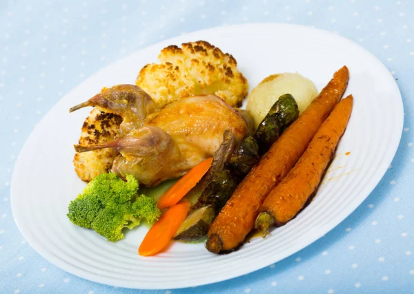Delicious poultry dish - partridge baked with vegetables in honey-mustard sauce