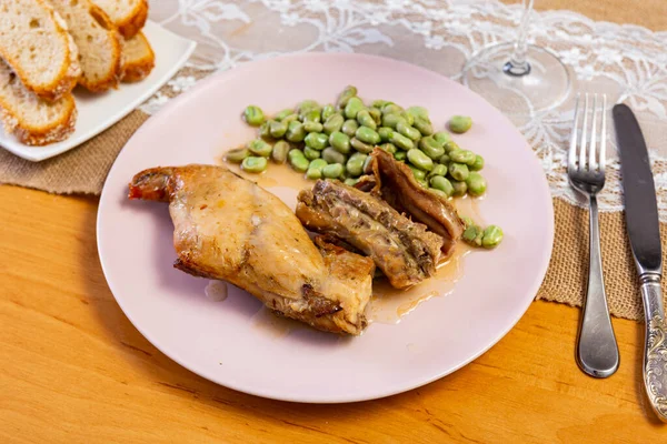 ローストウサギの足の美味しいディナーとホワイトプレートでスチード豆を提供 — ストック写真