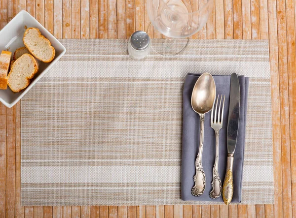 在木制桌子上有小桌布餐巾和餐具 配以透明的玻璃杯 还有小盘子和面包片 餐厅服务选项 — 图库照片