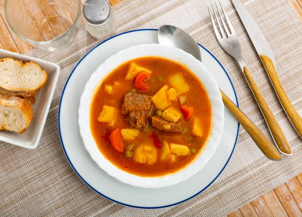 皿にジャガイモや野菜が入ったソースで美味しい蒸した豚肉 伝統的なスペイン料理パターナ エストファダス コンセプト — ストック写真