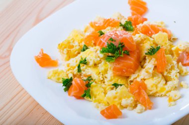 Image of plate with scrambled omlette with salmon at plate on table clipart