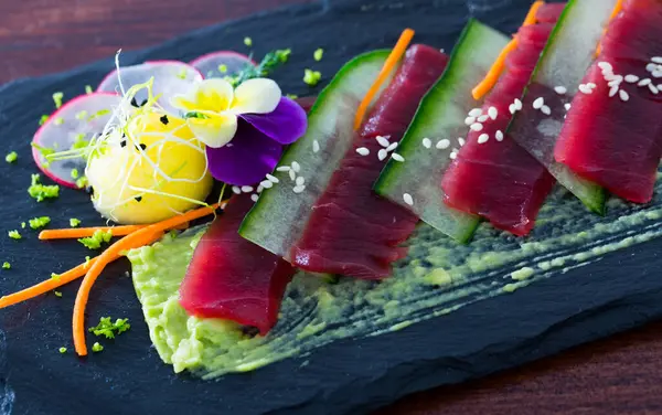 Raw Tuna Slices Black Slate Board Cucumber Guacamole Garnished Flower — Stock Photo, Image