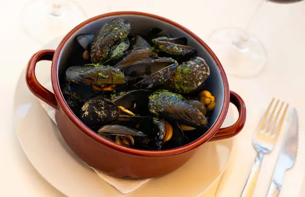 French dish - mussels with green sauce in copper cooking dish. High quality photo