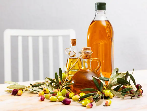 Butelki Karafki Świeżej Oliwy Oliwek Drewnianym Stole Gałązkami Oliwnymi Świeżymi — Zdjęcie stockowe