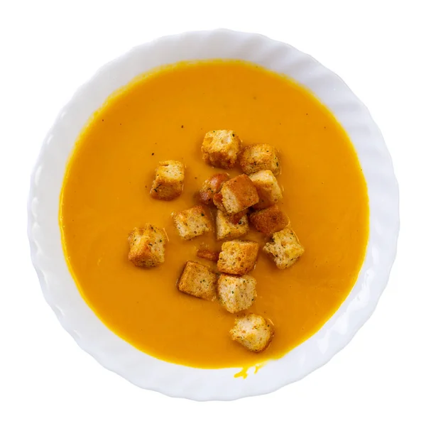 Light healthy carrot cream soup with croutons served in plate. Vegetarian concept. Gastronomic delight. Isolated over white background