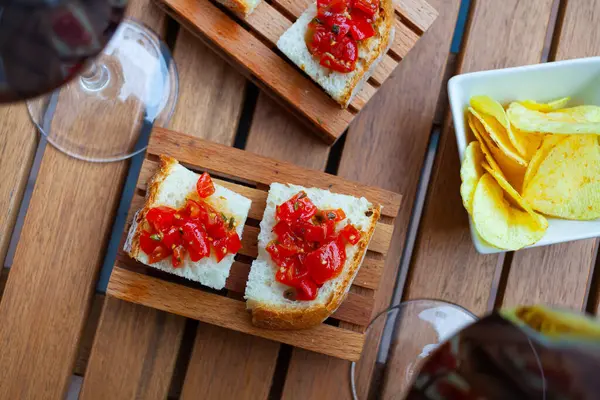 Pieces of grilled bread in Italian style with baked red sweet pepper. Mediterranean wine appetizer