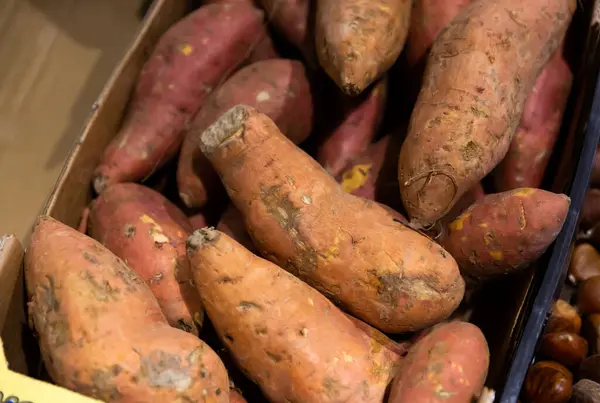 Raw sweet potato in box on farmers market