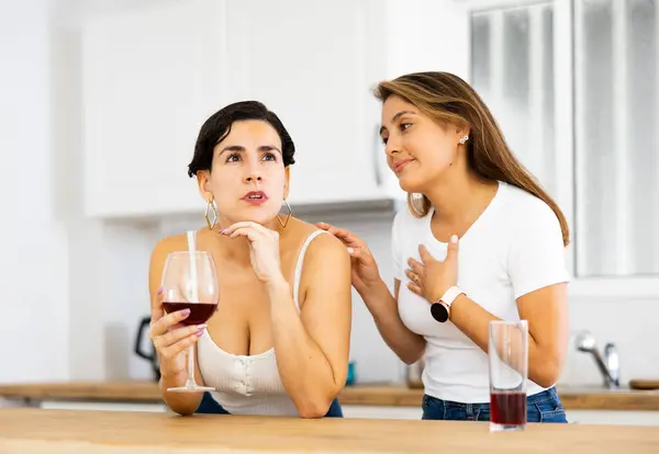 stock image Young woman consoling the depressed woman at table in kitchen