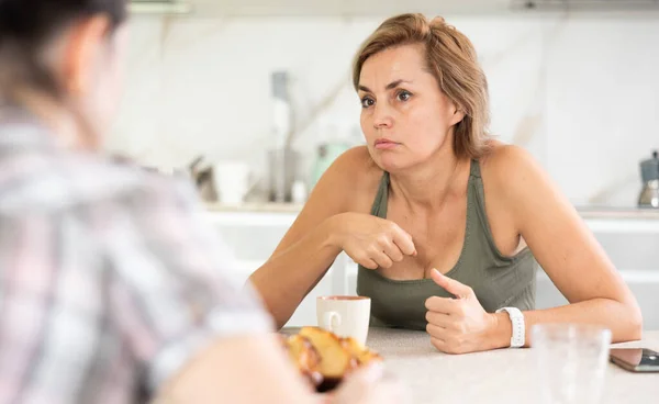 Two Women Sitting Kitchen Table Having Unpleasant Conversation Female Guest — Stock Photo, Image