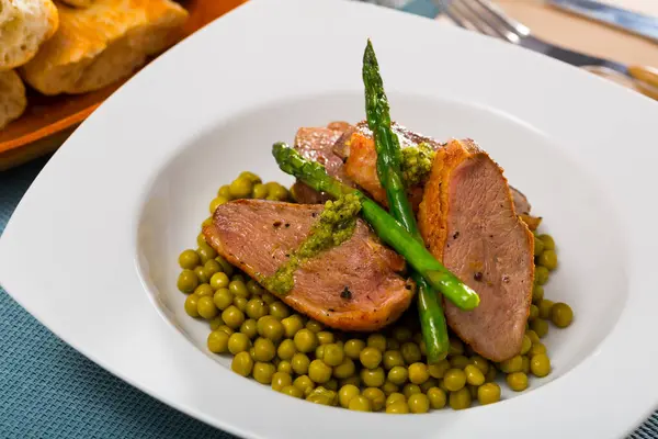 蒸しアスパラガスと缶詰の緑のエンドウ豆とおいしいアヒルの胸肉 — ストック写真