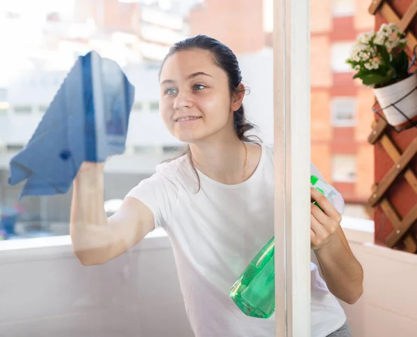 春を楽しみながらアパートの窓を洗う若い美しい女性の肖像画 — ストック写真