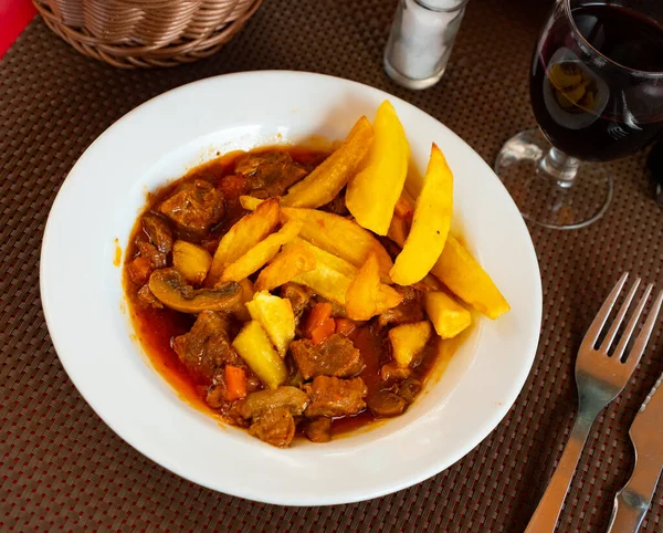 National French dish is Beef bourguignon, made from appetizing beef with wine, carrots, onions, mushrooms and served..with French fries