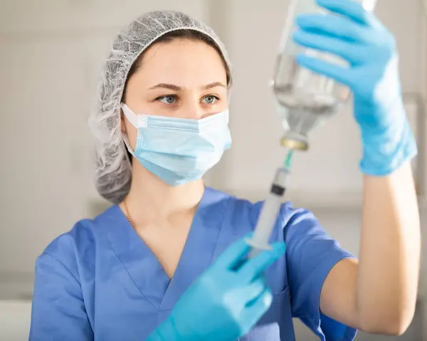 Pielęgniarka Masce Trzymająca Strzykawkę Wstrzykiwań Nowoczesnej Klinice — Zdjęcie stockowe