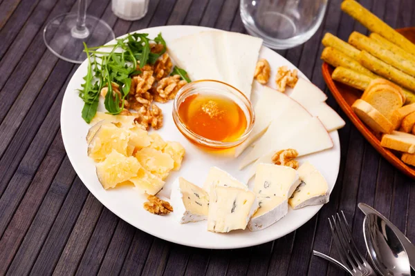 Slices Four Varieties Cheeses Plate Sweet Honey Walnuts Arugula Leaves — Stock Photo, Image