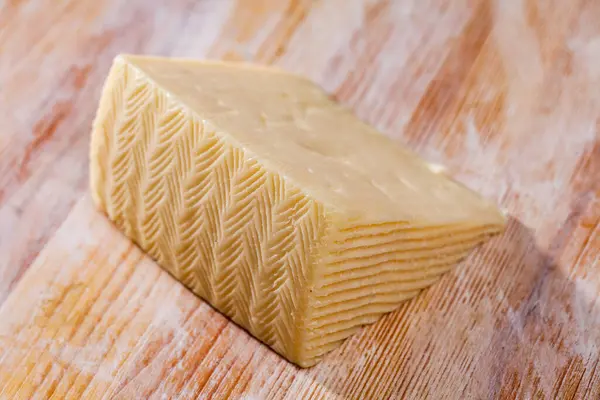 木のテーブルの上で半柔らかいチーズのスライス — ストック写真