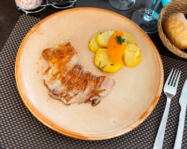 Secreto, Spanish and Portugal pork meat, served with sweetpotato puree and slices of potato tubers on table.