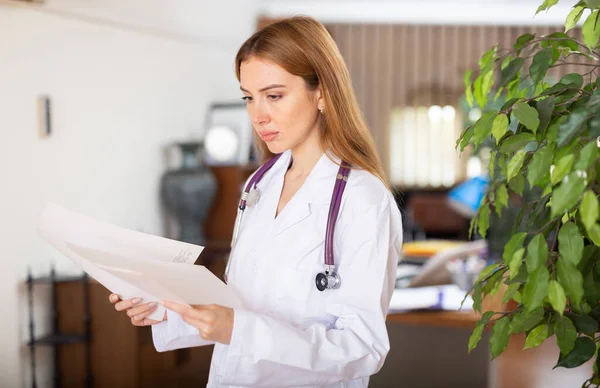 Unge Kvinnelige Terapeuter Studerer Viktige Medisinske Dokumenter Mens Står Klinikkkontoret – stockfoto