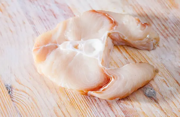 Image of steakes of raw shark fish on wooden table
