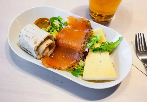 伝統的なスウェーデンの伝統的なスモーク トラウトと中ハードチーズのスライスには 経験の浅いフラットブレッド グリーン おいしいソースが添えられています — ストック写真
