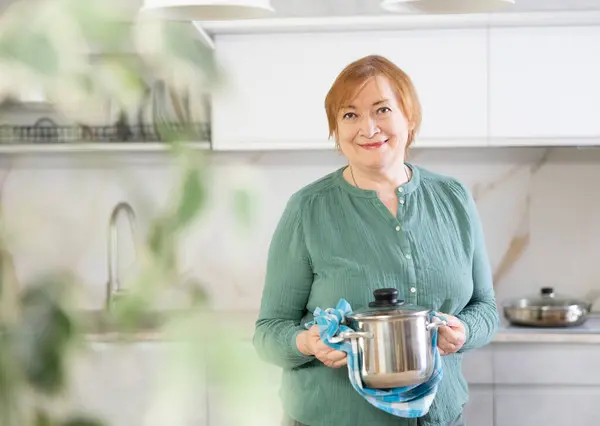 Dojrzała Kobieta Stoi Nowoczesnej Kuchni Domowej Trzyma Naczynia Stali Rękach — Zdjęcie stockowe