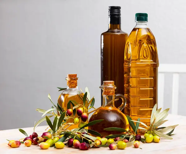 Bottled olive oil and branches with leaves and olives. High quality photo
