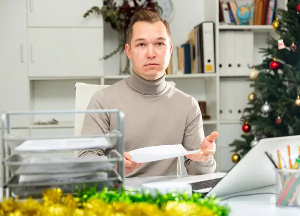 불만을 사무직 근로자가 크리스마스 기간에 식탁에 앉아서 작업을 — 스톡 사진