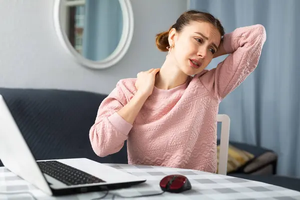Genç Bir Kadın Dizüstü Bilgisayarla Masada Oturuyor Boynuna Dokunuyor Boyun — Stok fotoğraf