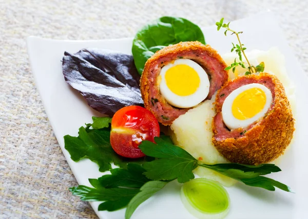 Dish of English cuisine - Scotch egg quail eggs served with potato puree and vegetables
