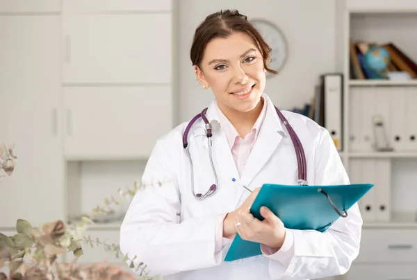 Pozytywna Kobieta Lekarz Stoi Dokumentami Klinice — Zdjęcie stockowe
