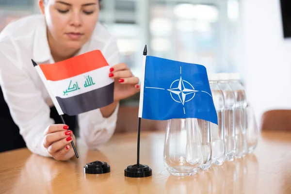 Jovem Roupas Negócios Coloca Bandeiras Otan Iraque Mesa Negociações Escritório — Fotografia de Stock