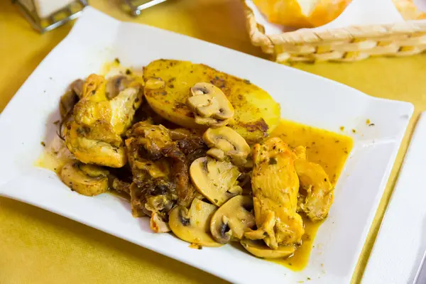 Tasty poultry dish - chicken served with baked potato and Champignon in garlic gravy