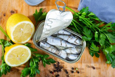 Open can of sardines on table. High quality photo clipart