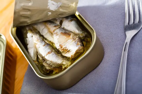 Tin can with smoked sprats, sardines, closeup. High quality photo