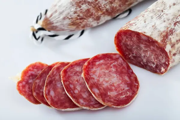 Traditional Catalan Dry Cured Pork Sausage Longaniza Sliced Pieces White Fotos de stock libres de derechos