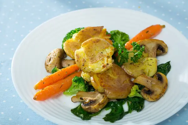 Dish of australian cuisine, crash hot potatoes with mushrooms and vegetables at plate